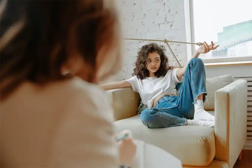 Woman with both legs up on the couch in therapy.