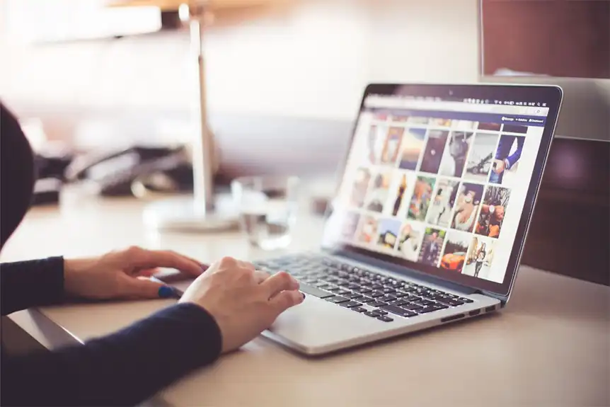 A woman using a laptop to pick images for her website.